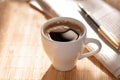 Cup of black coffee, newspaper and a pen against Royalty Free Stock Photo