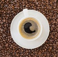 Cup of black coffee over bean covered background Royalty Free Stock Photo