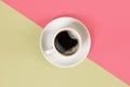 A cup of black coffee on pink and yellow background. View from above. Royalty Free Stock Photo