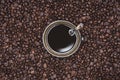 Cup of Black coffee placed, with Roasted Full frame coffee beans background