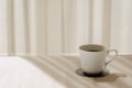 A cup of black coffee puts on white bed sheet