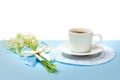 Cup of black coffee on a saucer and a bouquet of lily of the valley flowers on a white background with copy space. Royalty Free Stock Photo