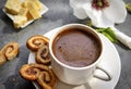 Cup of black coffee on a saucer with cookies, pieces of cheese, Magnolia flower on a gray background