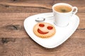 Cup of black coffee with smiled cookie. Funny breakfast