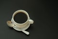 A cup of black coffee with a spoon on a saucer on a black isolated background Royalty Free Stock Photo