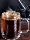 A cup of black coffee with steam on wooden table. A glass mug of hot coffee. Morning coffee Royalty Free Stock Photo