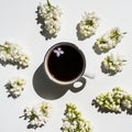 A cup of black coffee on the table with a branch of lilac, top view. Coffee and different lilac flowers. Royalty Free Stock Photo