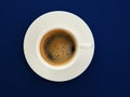 A cup of black coffee on a trendy blue background, top view. Espresso or americano. Cafe and bar, barista art concept. Minimalism Royalty Free Stock Photo
