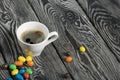 A cup of black coffee in a white cup. Chocolate candy in glaze. On pine boards Royalty Free Stock Photo