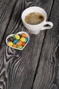 A cup of black coffee in a white cup. Chocolate candy in glaze. On pine boards Royalty Free Stock Photo