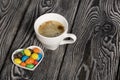 A cup of black coffee in a white cup. Chocolate candy in glaze. On pine boards Royalty Free Stock Photo