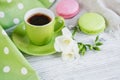 Cup of black coffee, white freesia flowers and sweet pastel french macaroons Royalty Free Stock Photo