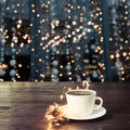 Cup of black coffee on wooden table in cafe. Christmas lights and gold garland on background Royalty Free Stock Photo