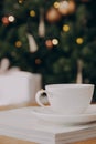 Cup of black coffee on wooden table in cafe. Christmas lights and gold garland on background. Atmospheric winter hygge Royalty Free Stock Photo