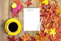 Cup with black coffee, pen, notepad, wooden table with autumn fallen orange leaves Flat lay Top view Mock Royalty Free Stock Photo