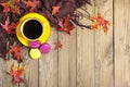 Cup with black coffee, yellow lollipops, macaroons, textile scarf, notepad, wooden table with autumn fallen orange leaves Royalty Free Stock Photo