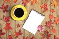 Cup with black coffee, yellow lollipops, macaroons, textile scarf, notepad, wooden table with autumn fallen orange leaves Royalty Free Stock Photo