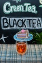 Cup with black tea on the background of graffiti with inscriptions and drawings on a blackboard