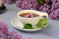 cup with black tea close-up and lilac flowers nearby Royalty Free Stock Photo