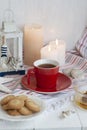 A cup of black tea with homemade cookies on a striped tablecloth, a bowl honey, a decorative lantern, seashells; wax candles on Royalty Free Stock Photo