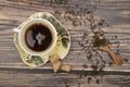 A Cup of black tea, tea leaves in a wooden spoon, pieces of brown sugar on a wooden background. Close up Royalty Free Stock Photo