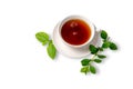 A Cup of black tea on a saucer with mint leaves on a white isolated background. Royalty Free Stock Photo