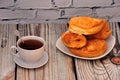 A cup of black tea on the table and a plate with an assortment of fresh puff pastries Royalty Free Stock Photo