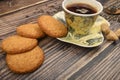 A Cup of black tea, tea leaves, pieces of brown sugar, oatmeal cookies on a wooden background. Close up Royalty Free Stock Photo