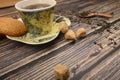 A Cup of black tea, tea leaves, pieces of brown sugar, oatmeal cookies on a wooden background. Close up Royalty Free Stock Photo