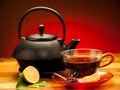 A cup of black tea with teapot in the background Royalty Free Stock Photo