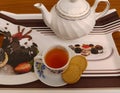 Cup of black tea with two biscuits and teapot on a tray Royalty Free Stock Photo