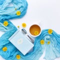 Cup of black tea with yellow daisy flowers and blue scarf on white background. Royalty Free Stock Photo