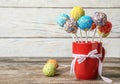 Cup with bow and yummy colorful cake pops on table Royalty Free Stock Photo