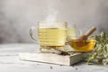 Cup with buckwheat tea, granules and honey, light grey background. Superfood Taiwan Ku Qiao buckwheat tea and grits of tartary