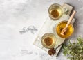 Cup with buckwheat tea, granules and honey, light grey background. Superfood Taiwan Ku Qiao buckwheat tea and grits of tartary