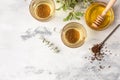 Cup with buckwheat tea, granules and honey, light grey background. Superfood Taiwan Ku Qiao buckwheat tea and grits of tartary