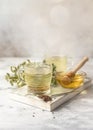 Cup with buckwheat tea, granules and honey, light grey background. Superfood Taiwan Ku Qiao buckwheat tea and grits of tartary