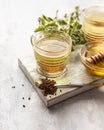 Cup with buckwheat tea, granules and honey, light grey background. Superfood Taiwan Ku Qiao buckwheat tea and grits of tartary