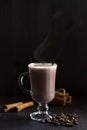 Cup of cacao. glass of hot chocolate with whipped cream, coffee beans and cinnamon sticks on a dark background. Royalty Free Stock Photo