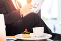 Cup cake and coffee in dish and blur business man read newspaper Royalty Free Stock Photo