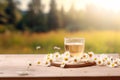 A cup of camomile tea on wooden table and camomile flowers in the morning with nature background. Generative AI Royalty Free Stock Photo