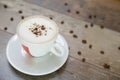 Cup of cappuccino and beans on a wooden table Royalty Free Stock Photo