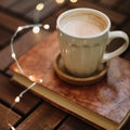 Cup of cappuccino with a book on dark wooden background. Coffee break. Top view. flatlay. cozy home