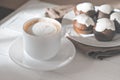 cup of cappuccino and chocolate muffins on white wooden cafe table. morning light. good morning concept. capuccino frost Royalty Free Stock Photo