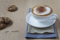 Cup of cappuccino with cocoa on wooden Table