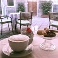 A cup of capuccino coffee on an outside cafe table with a view of a quiet Venice street Royalty Free Stock Photo