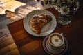 Cup of cappuccino coffee and croissant / brioche on a wooden table with freshly gathered daisy flowers. Italian breakfast. Royalty Free Stock Photo