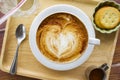 Cup of cappuccino coffee with heart shape latte art on old wood table Background, Latte coffee on old wooden Background table Royalty Free Stock Photo