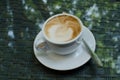The cup of cappuccino on the glass surface Royalty Free Stock Photo