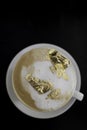 Cup of cappuccino with a golden foam, luxury drink concept.